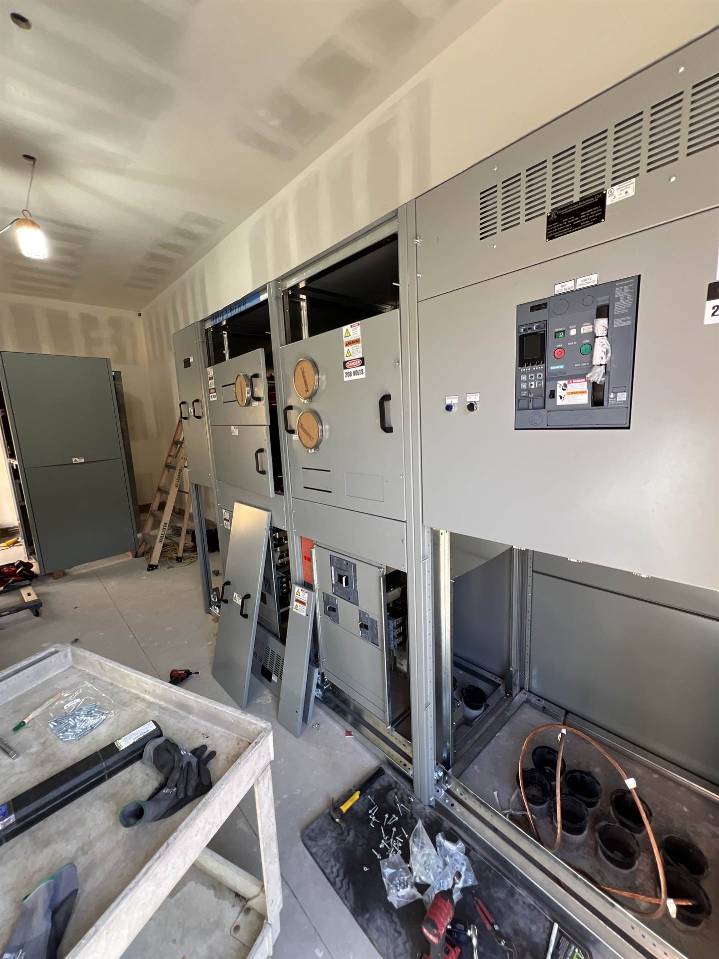 Electrician inspecting a commercial switchgear breaker panel